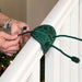 Individual tying protective garland ties to banister Thumbnail | Christmas World